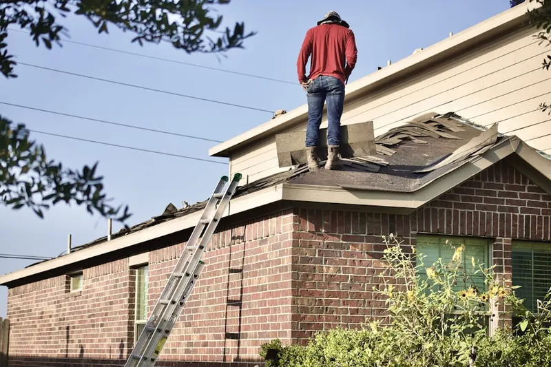 Professional roofer working on a residential roof in Randolph Town